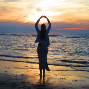 太陽の昇る海岸と人