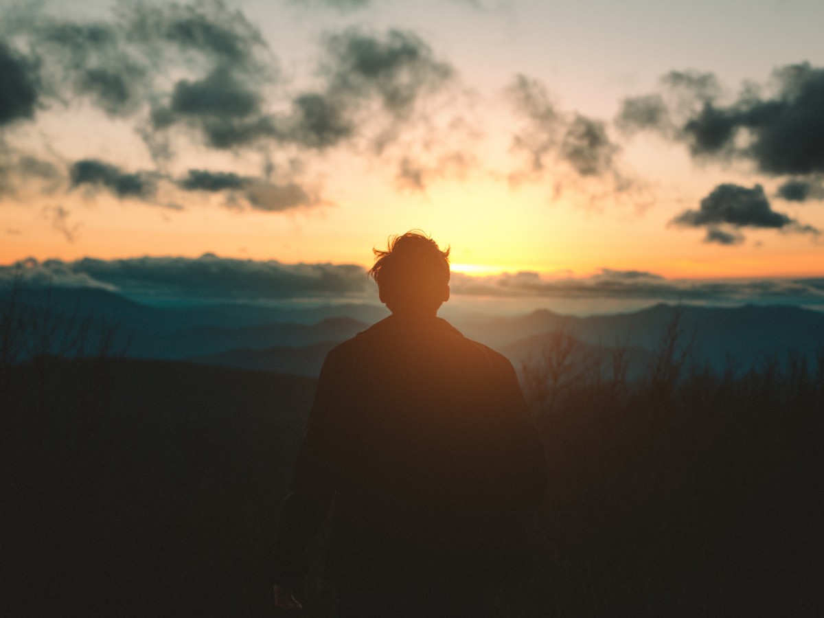 海から昇ってくる太陽を見つめる人