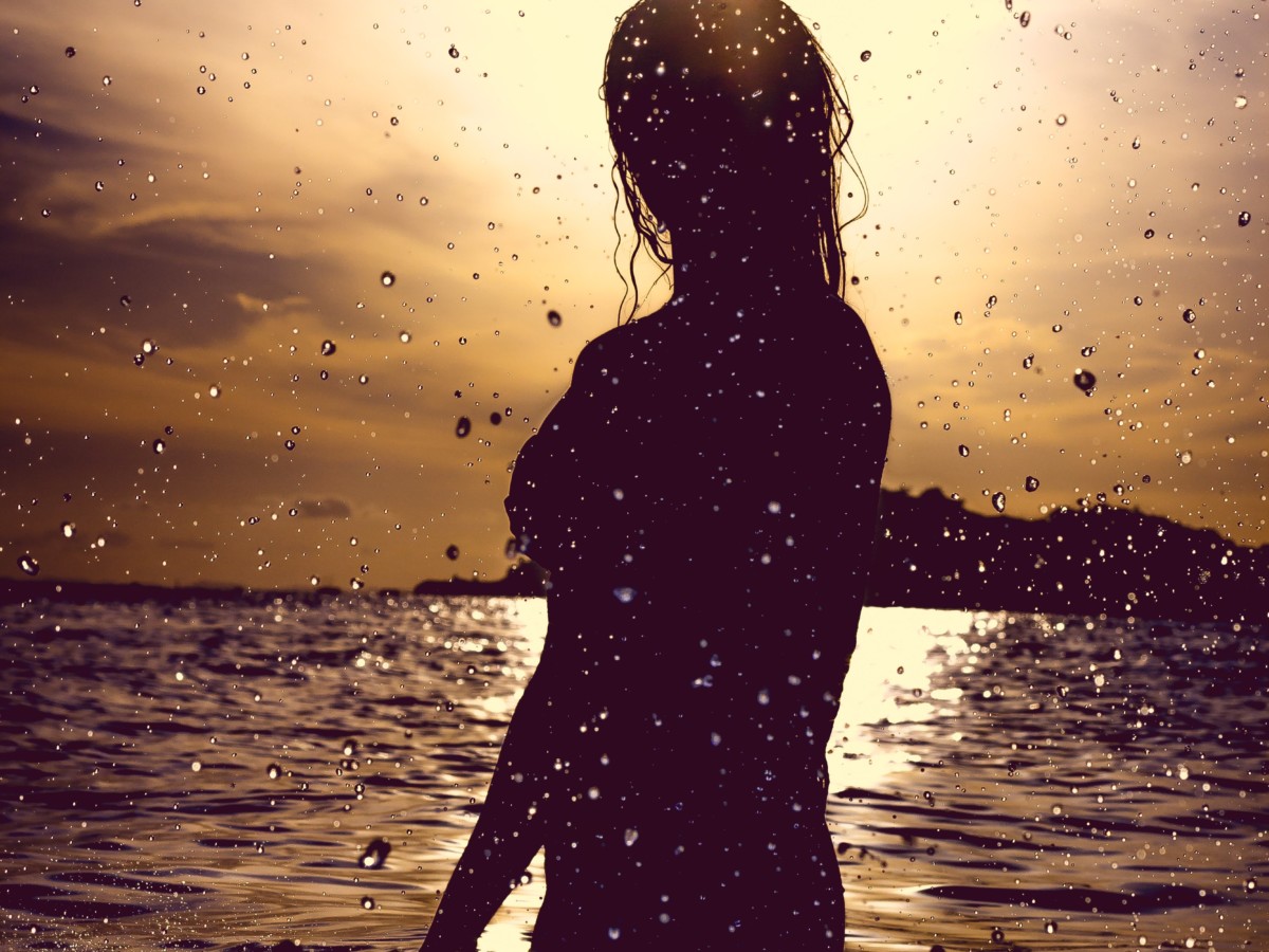 朝日のなかで海で泳ぐ人