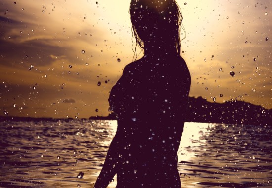 朝日のなかで海で泳ぐ人